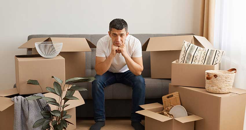 Unhappy Man Unpacking Boxes